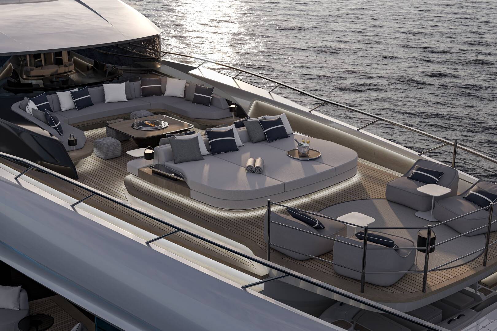 Meta Design Studio, Yacht Animation, 3D Animation, Yacht Rendering, 3D Rendering, Luxury Visualization, Yacht Visualization A luxurious yacht deck with modern, curved seating areas, plush cushions, tables, and ambient lighting overlooks calm ocean waters at sunset.