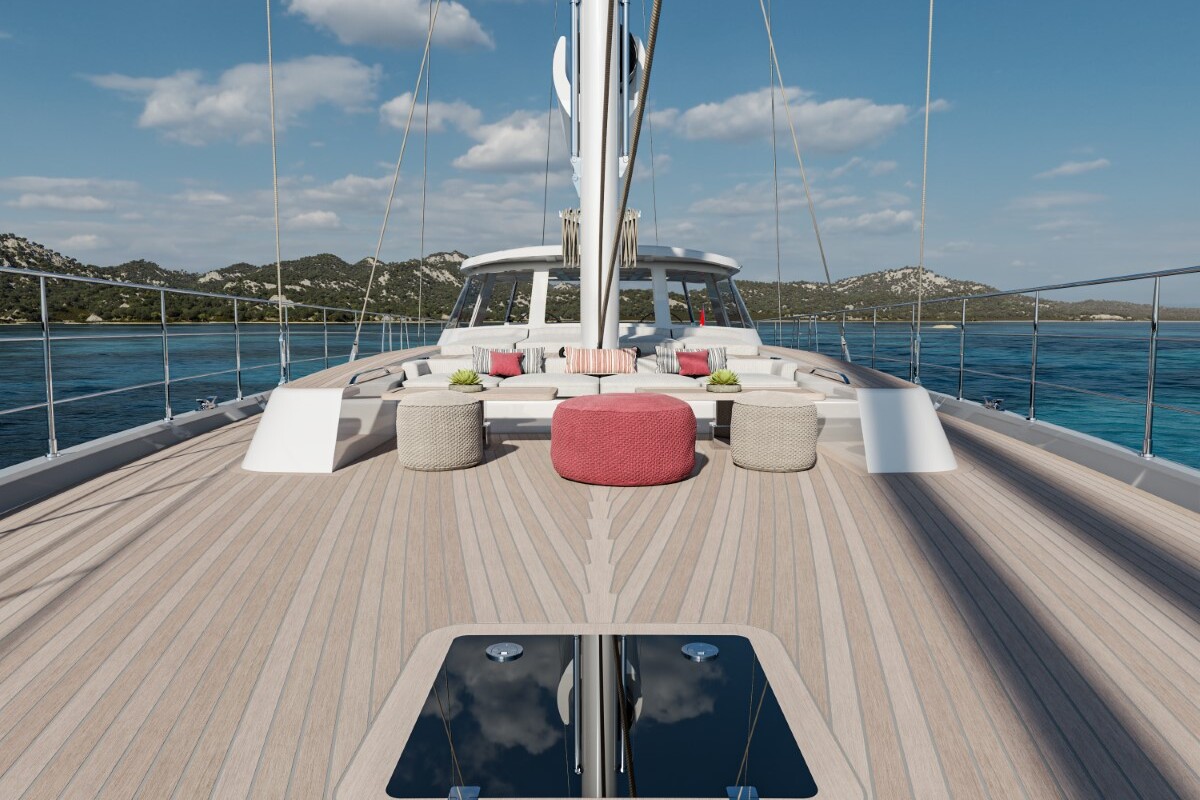 Meta Design Studio, Yacht Animation, 3D Animation, Yacht Rendering, 3D Rendering, Luxury Visualization, Yacht Visualization The image shows the deck of a luxury yacht with light wood flooring, cushioned seating, and a round red ottoman. The yacht is on calm blue water with scenic hills and a partly cloudy sky in the background.